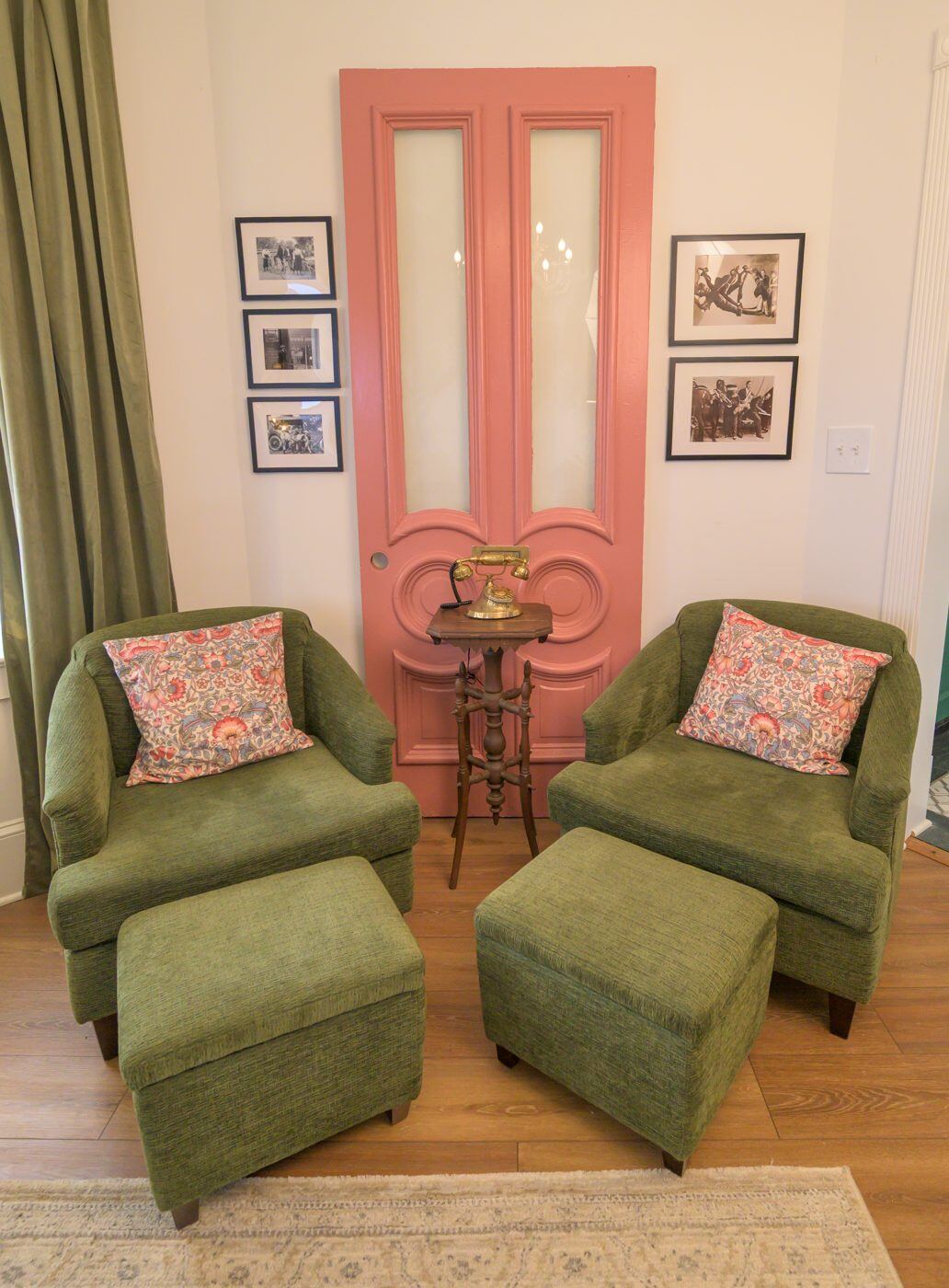 A coral-framed doorway with a pair of green velvet chairs at the Craven House