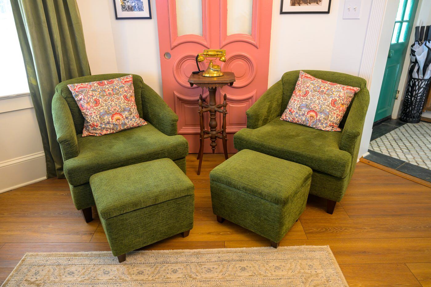 A cozy green velvet reading nook with a gallery wall at the Craven House
