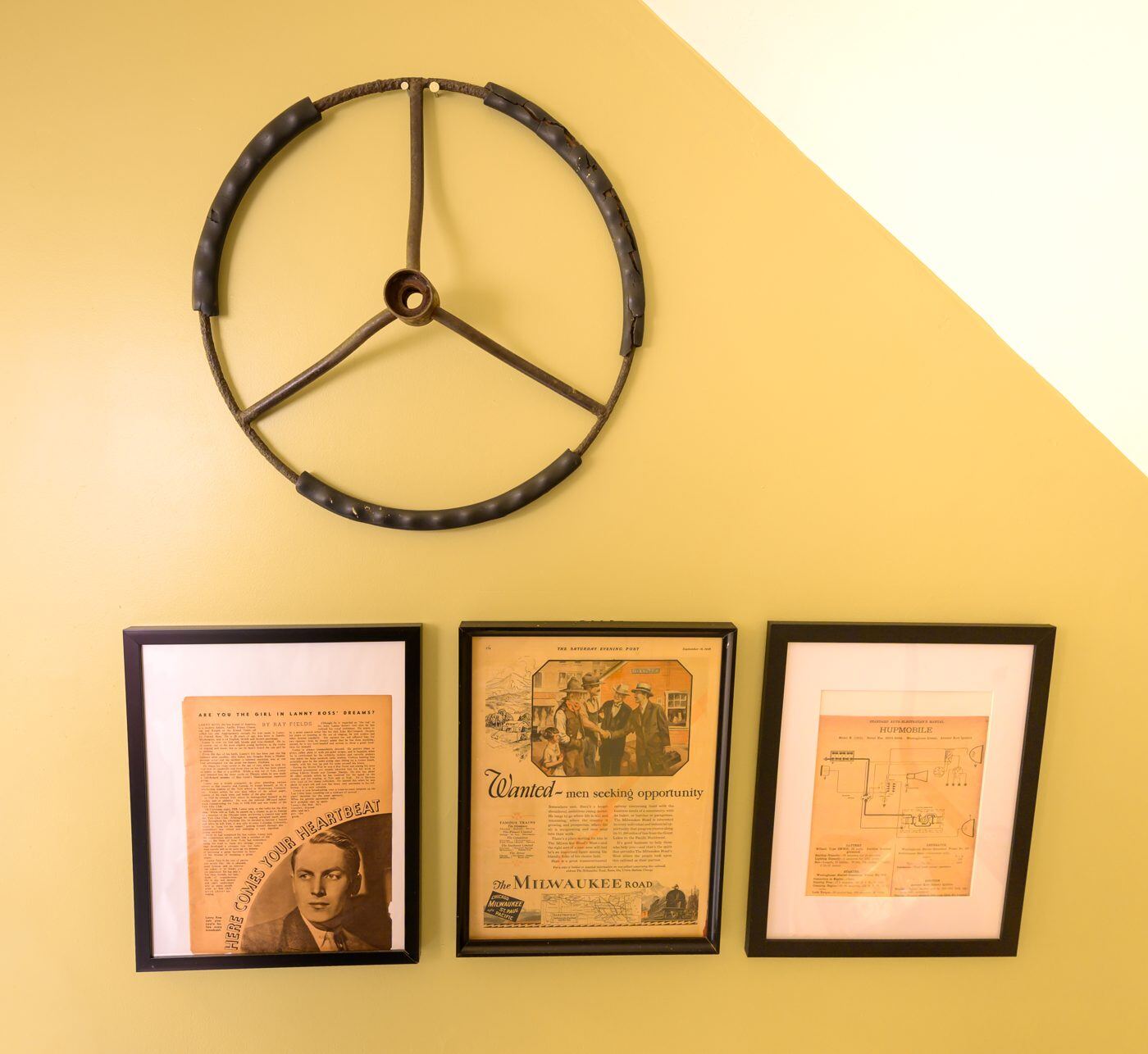A sunny yellow wall styled with decorative wall art and framed vintage prints at the Craven House